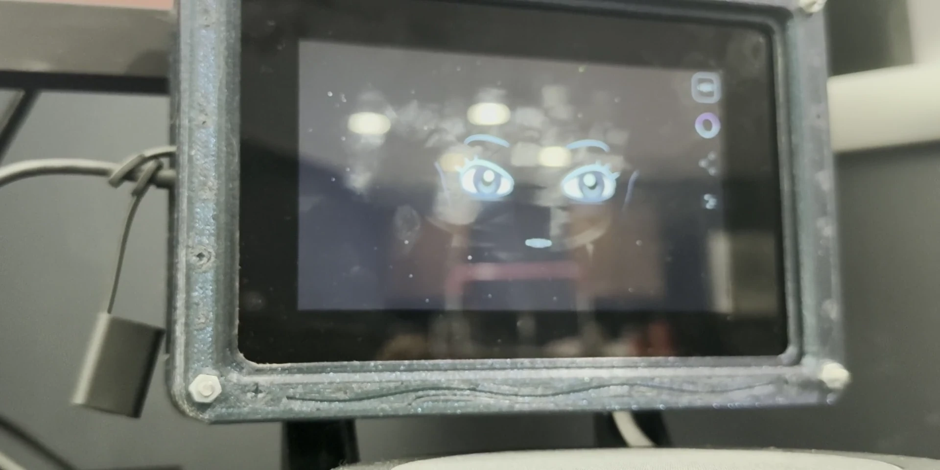 Prototype footage: the hand-built physical unit at rest on a desk, its display showing the assistant.